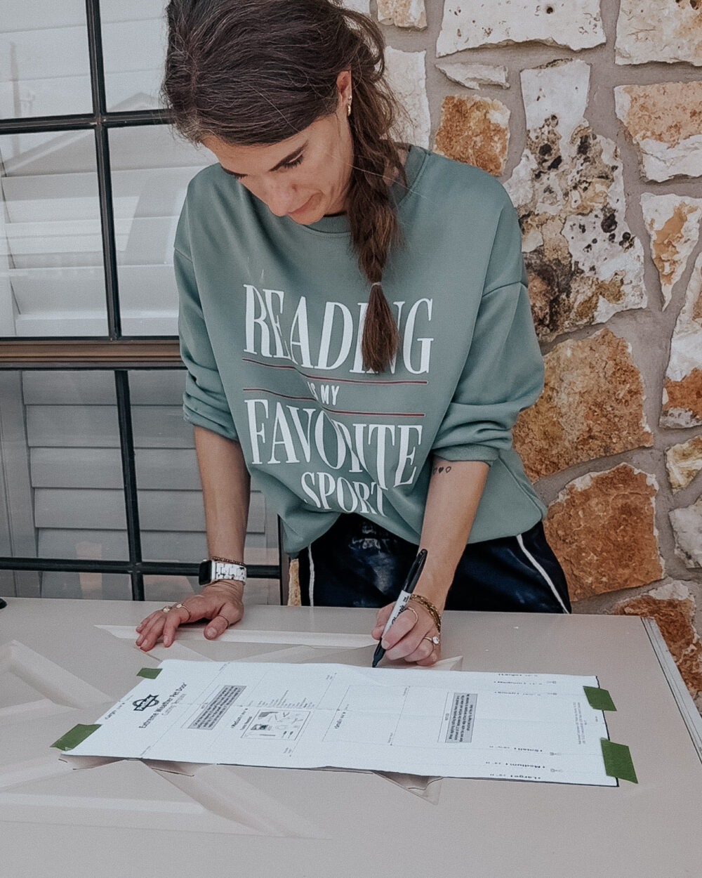 woman using a template to mark a hole for a pet door