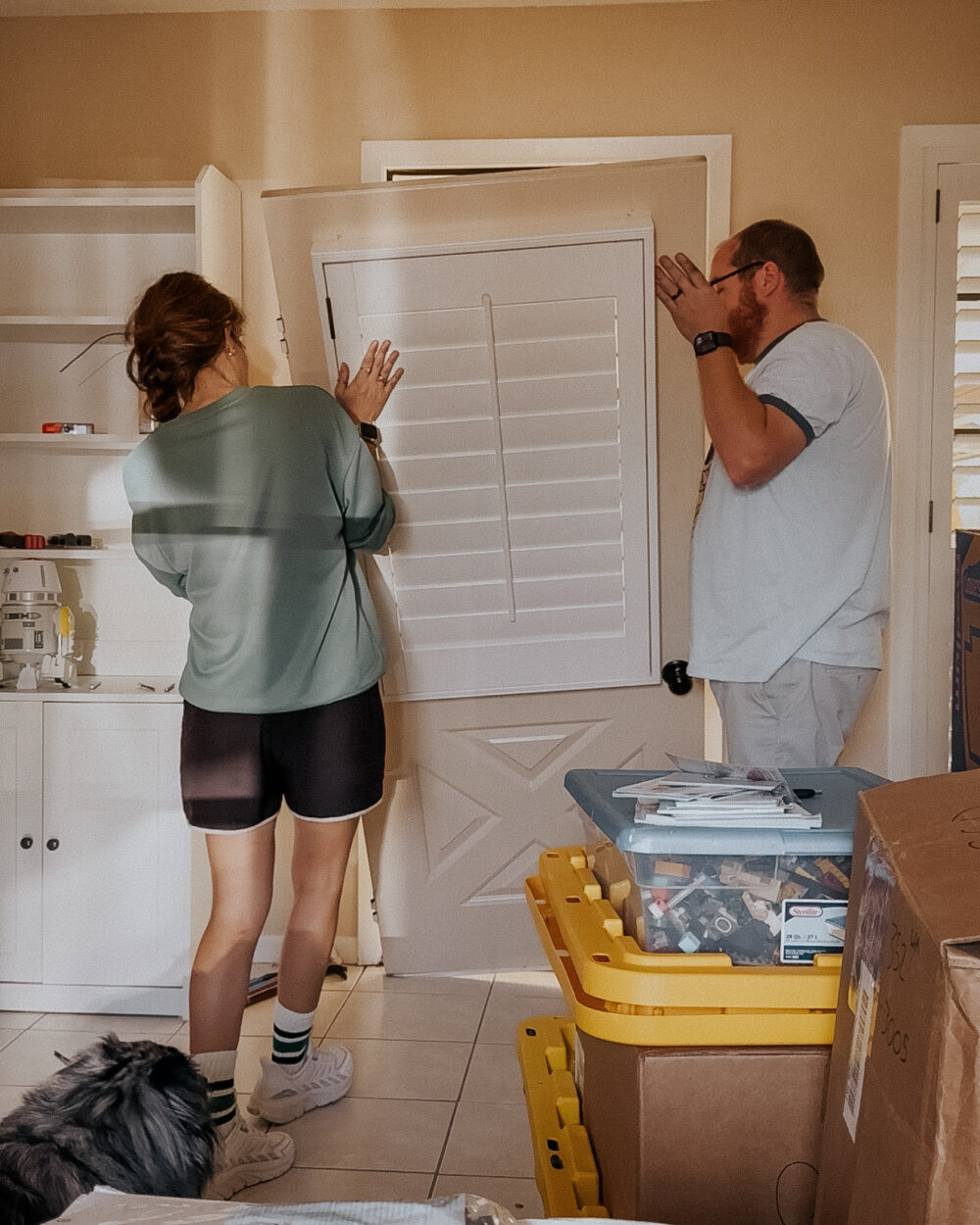 man and woman removing a back door to install a pet door