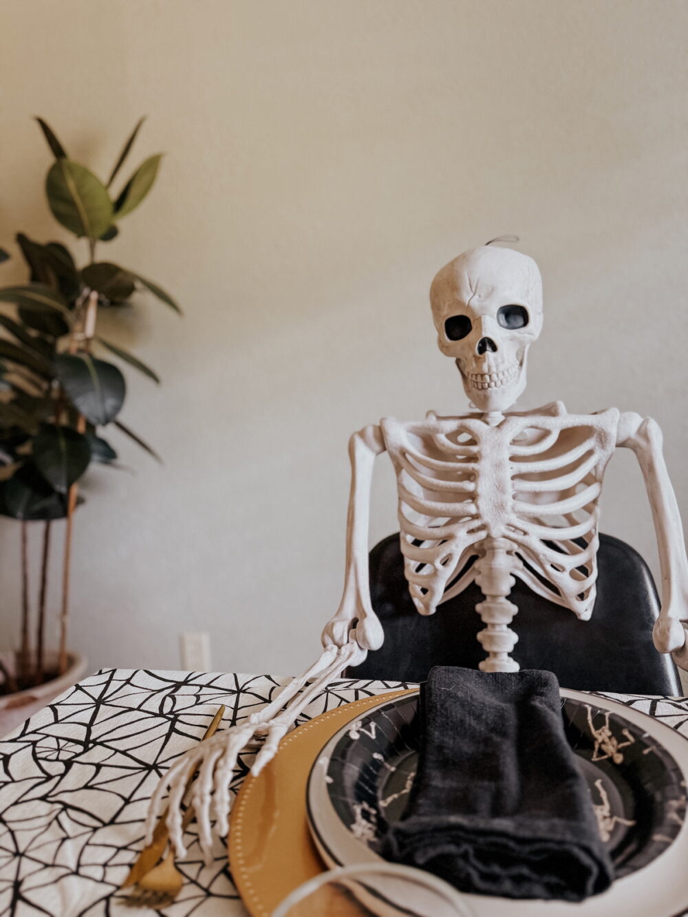 large skeleton sitting at a table 