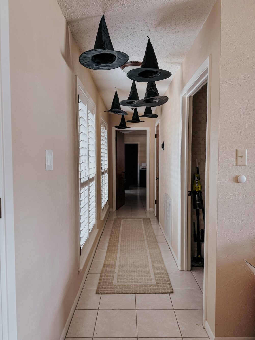 witch hats hanging in a long hallway