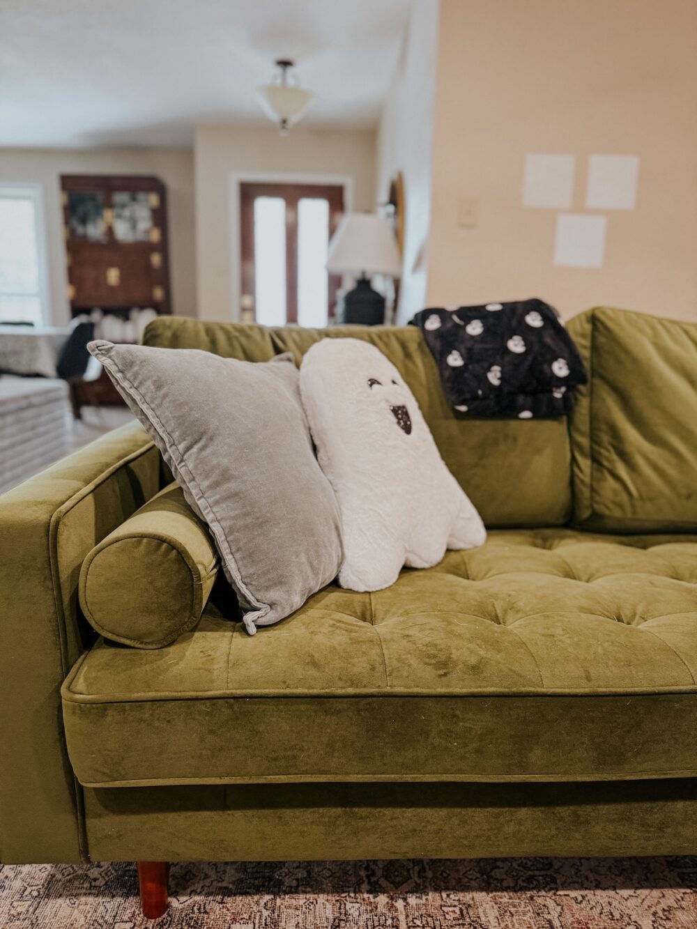 living room sofa with a Halloween throw pillow and blanket