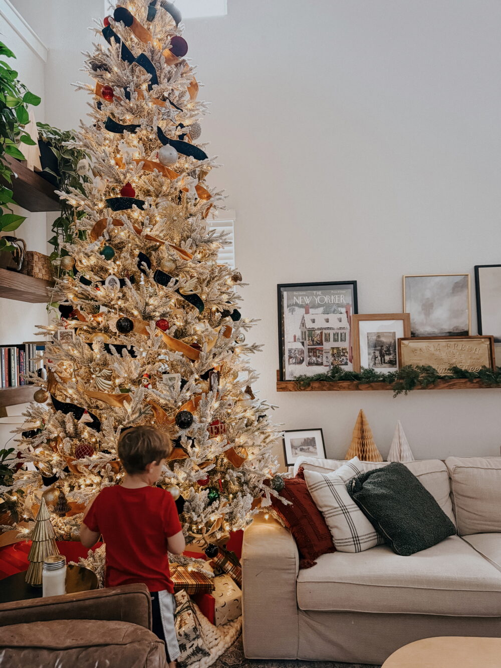 Young boy standing in front of a tall Christmas tree