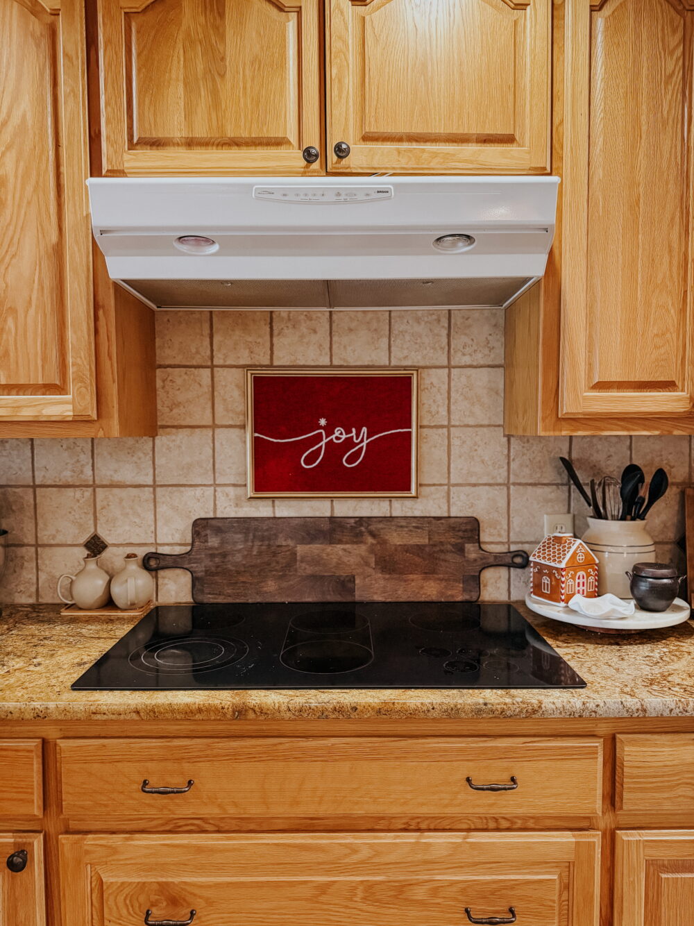 stove with Christmas art hung above it