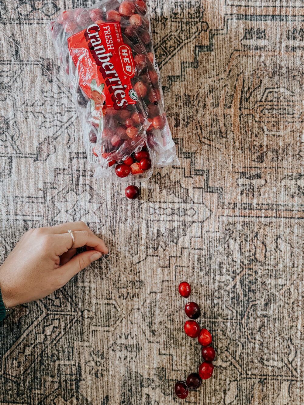 woman's hands making a cranberry garland