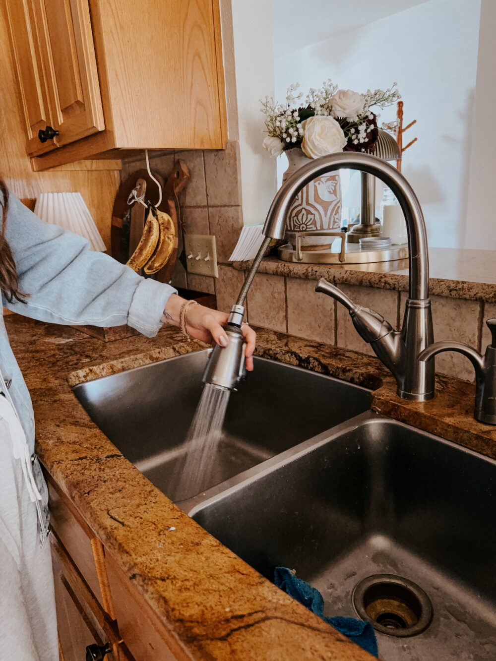 woman rinsing a stainless steel sink