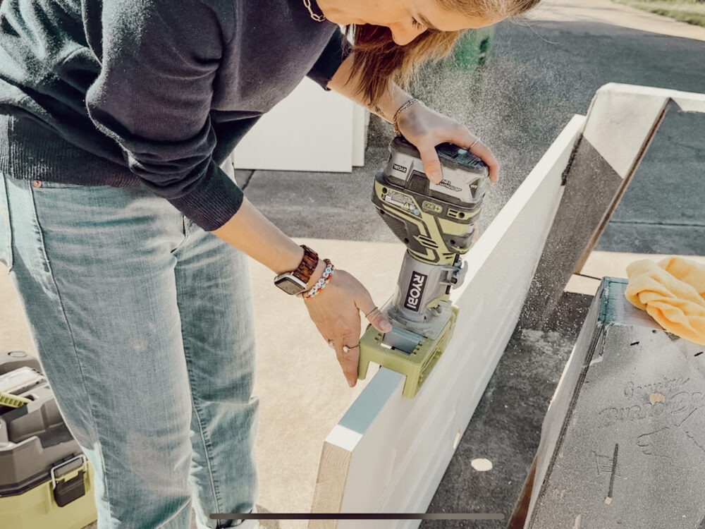 woman using a ryobi router to route out a hole for an interior door hinge