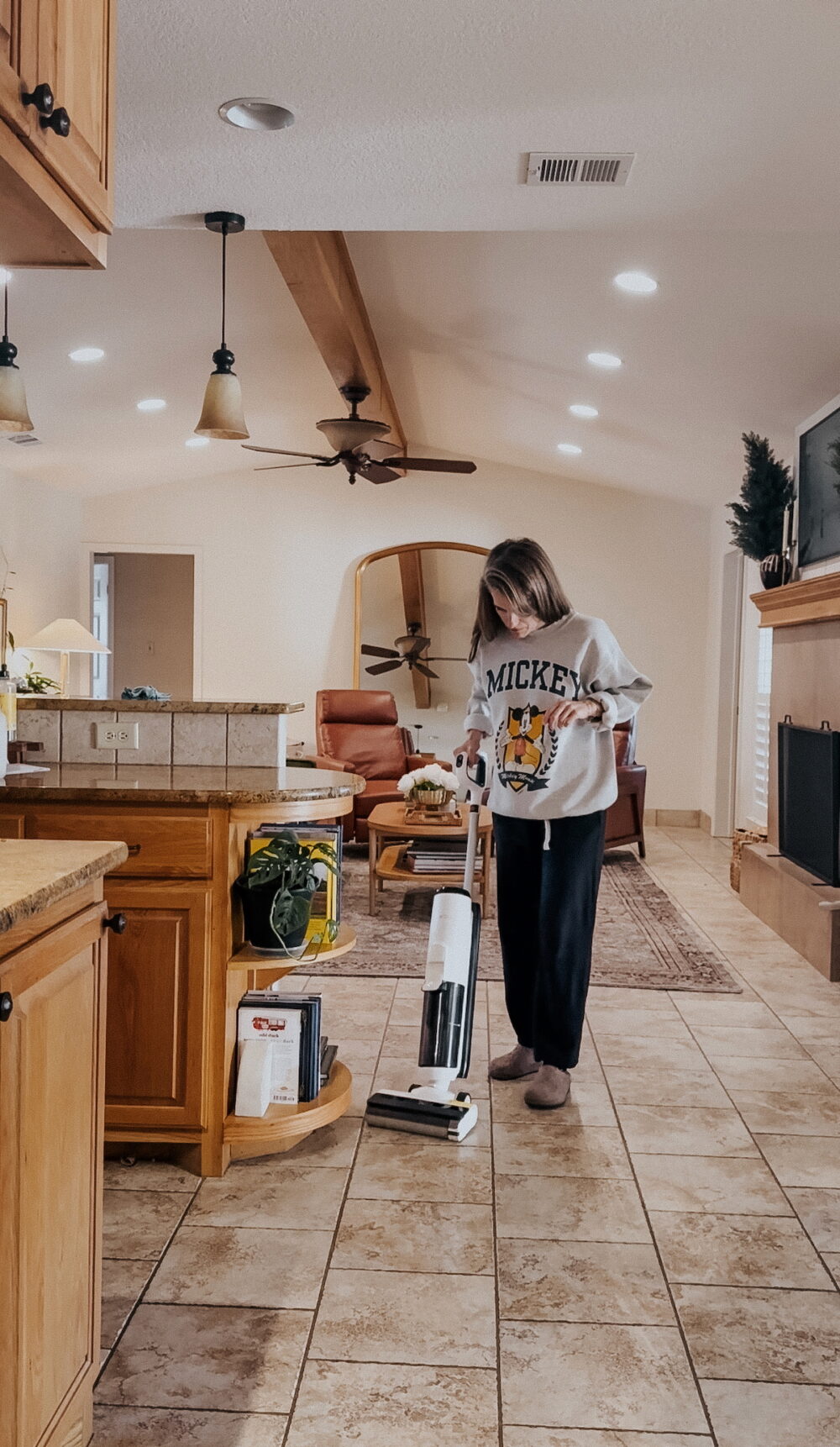 woman cleaning kitchen floor with a tineco wet dry vaacuum