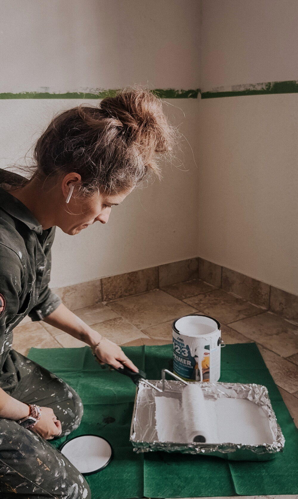 woman applying drywall primer to a paint roller