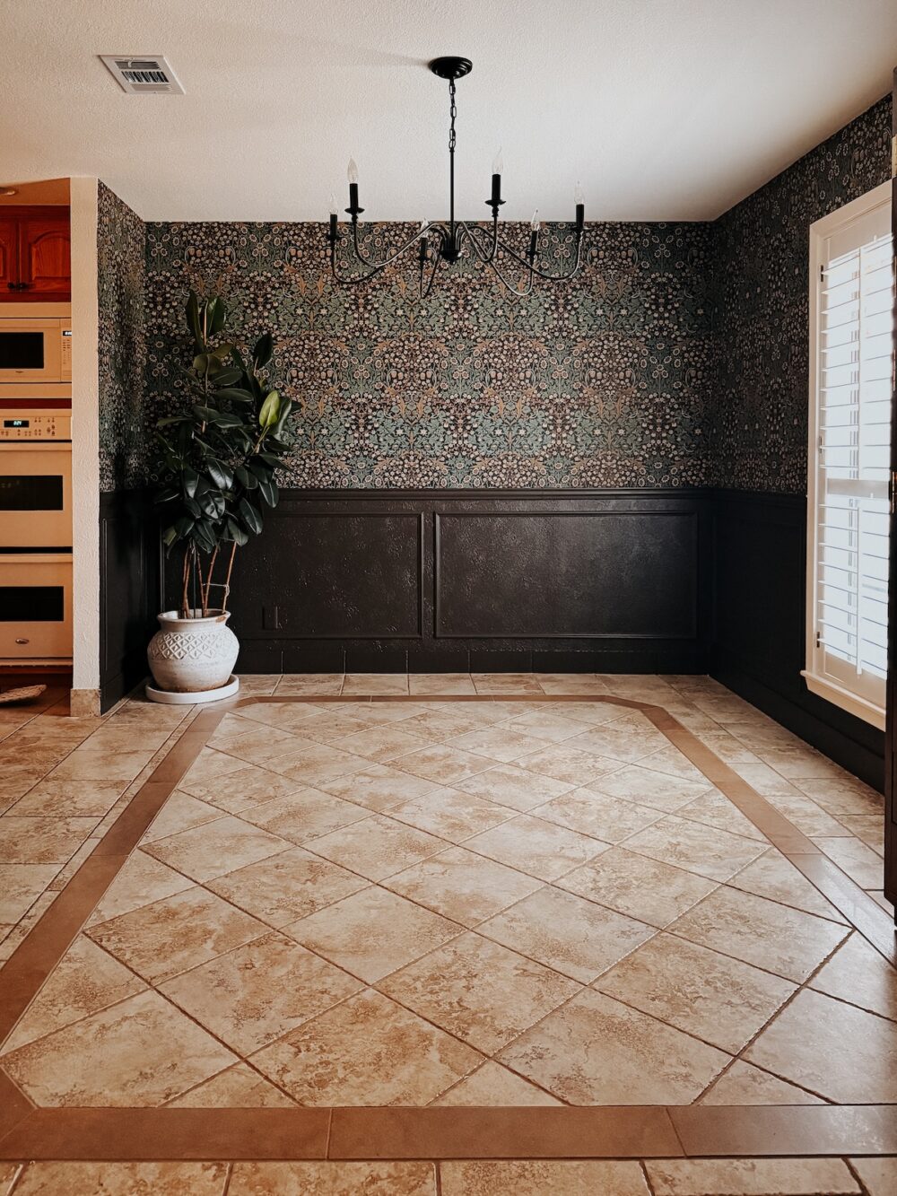 empty moody traditional dining room with wallpaper and trim painted brown
