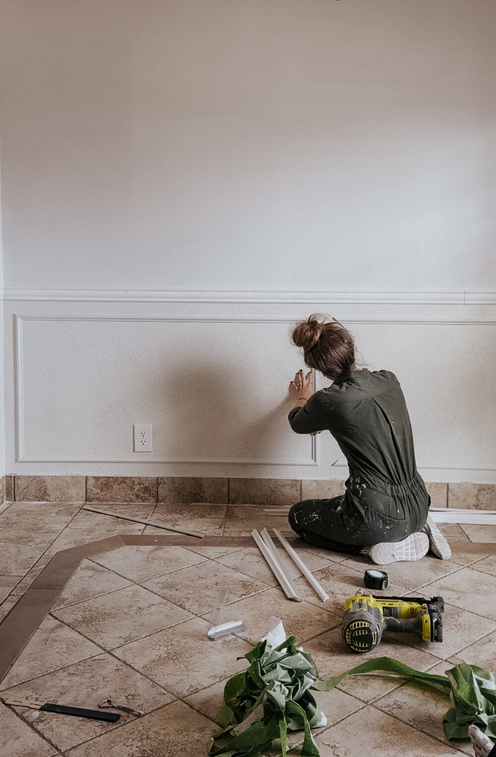 woman installing box trim in a dining room