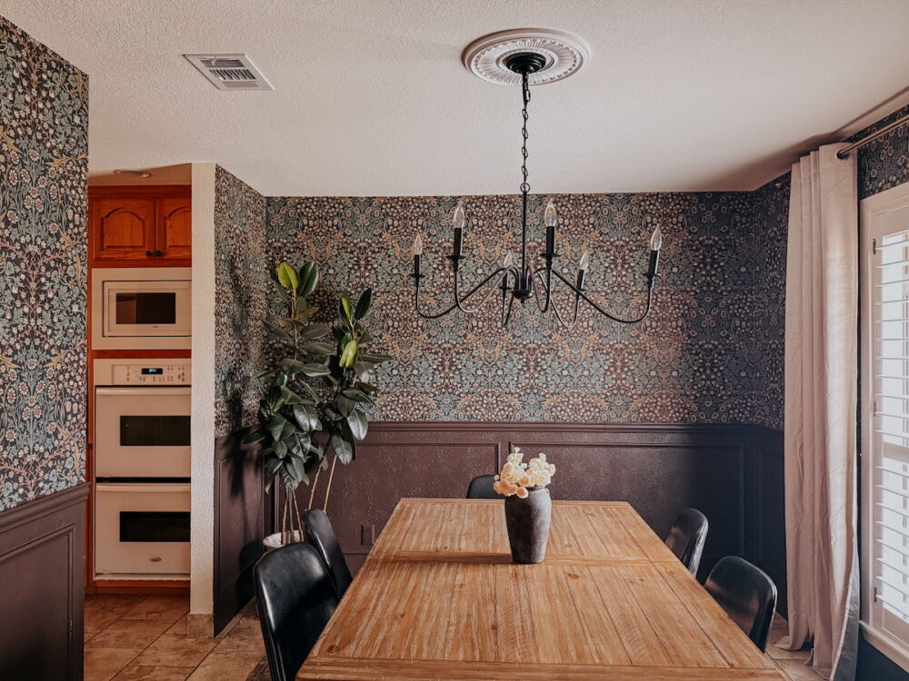 dining room with wallpaper, dark brown walls, and traditional finishing touches