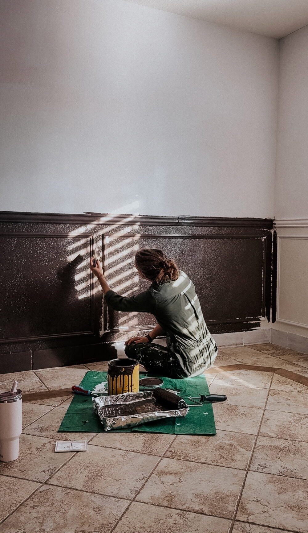 woman painting a wall brown