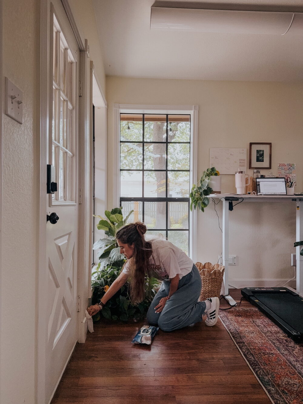 woman cleaning baseboards in an office