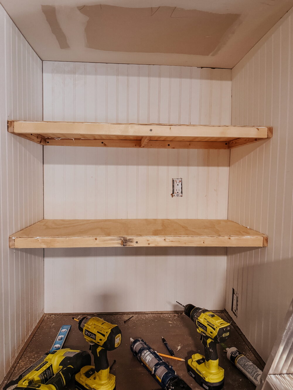 in-progress DIY floating shelves, with plywood installed on the top