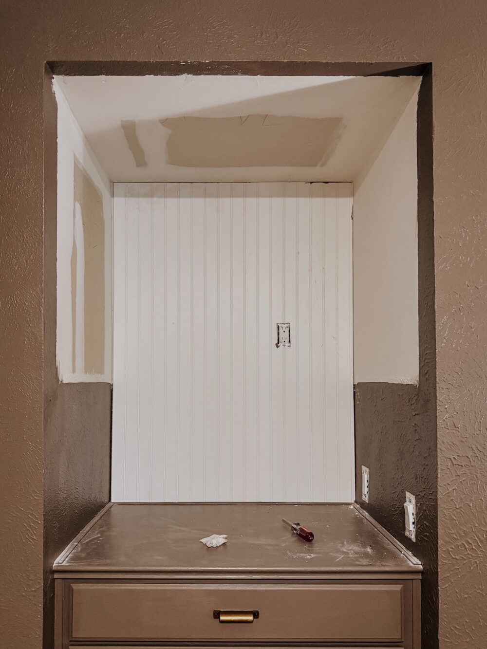 empty 3-sided nook with beadboard being installed on the walls