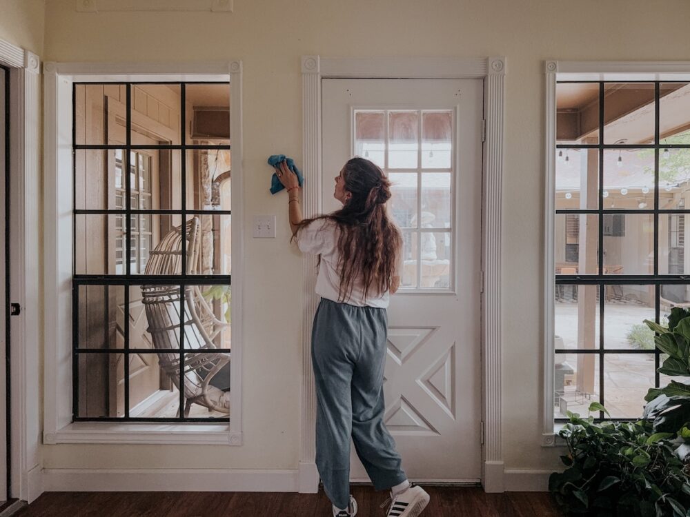 woman using a microfiber cloth to clean the walls