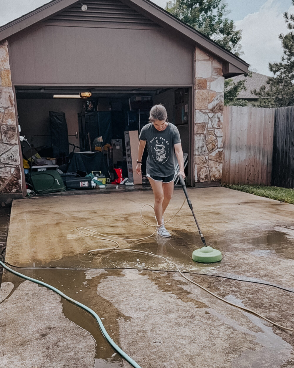 woman cleaning with a pressure washer with a surface cleaner attachment
