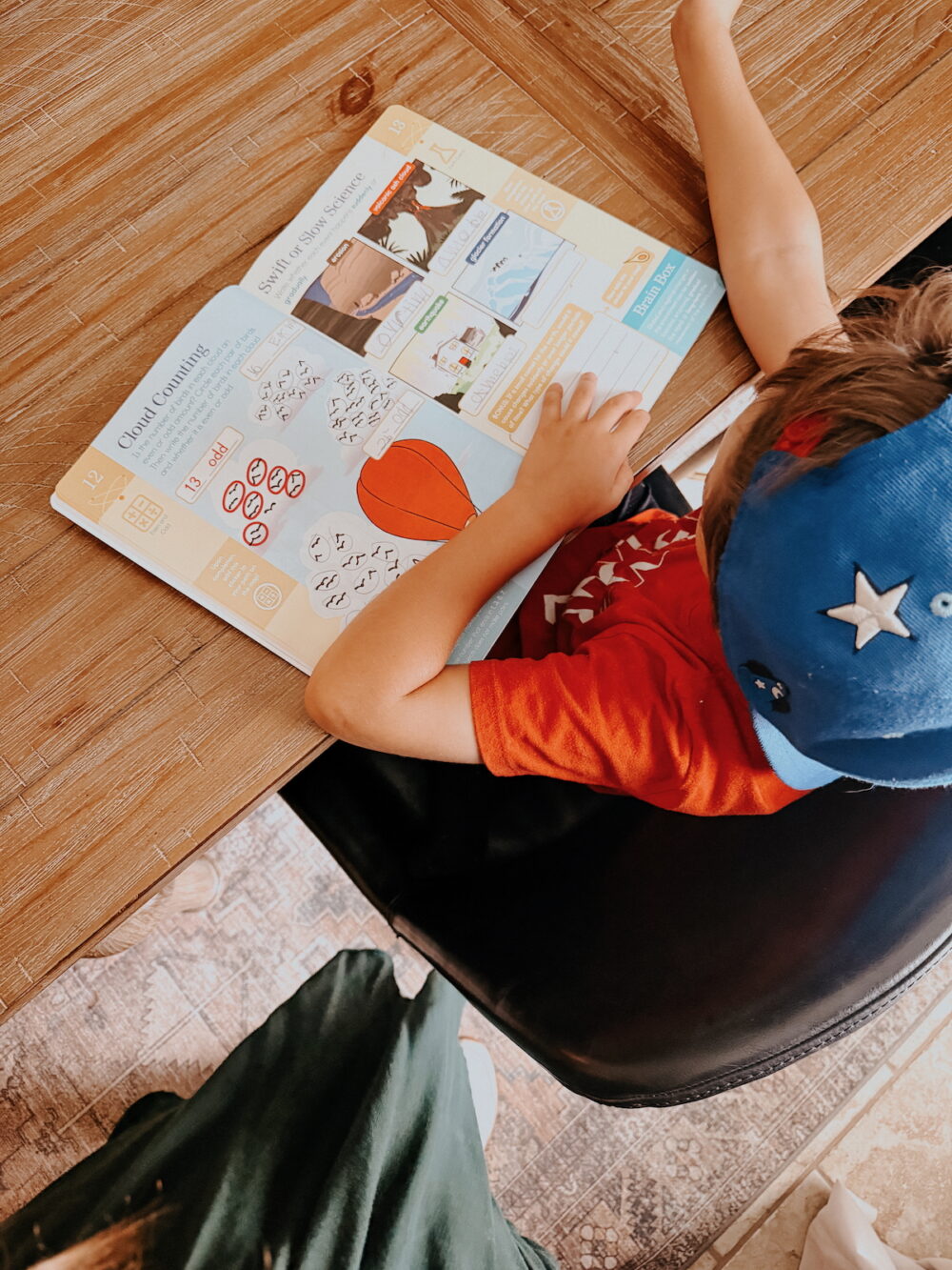 overhead view of a young boy working on a summer workbook