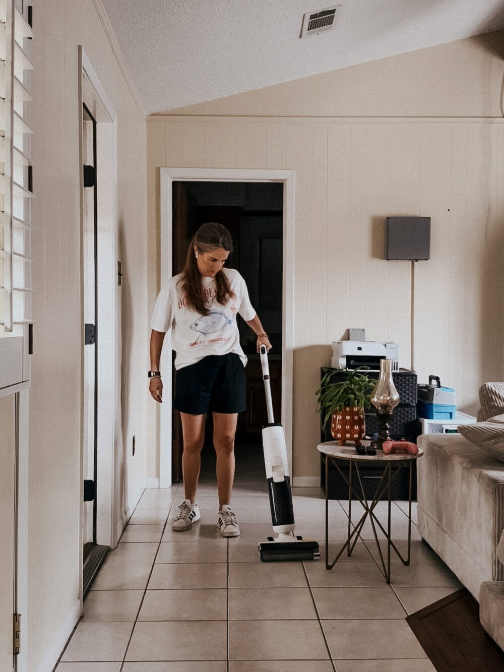 woman using a wet dry vacuum to deep clean a family room