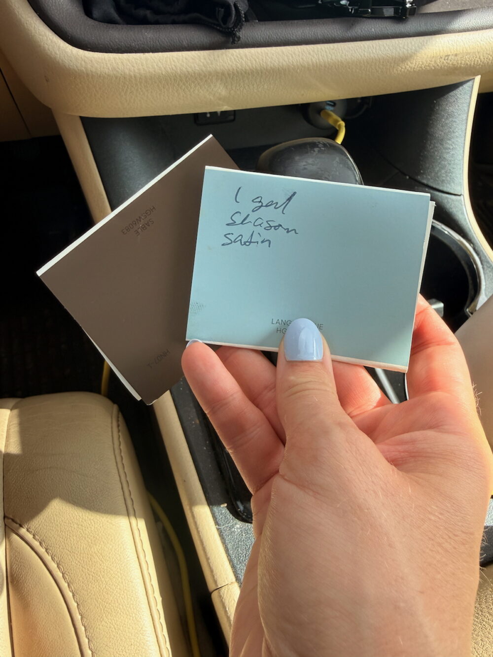 paint swatches held next to each other in a car
