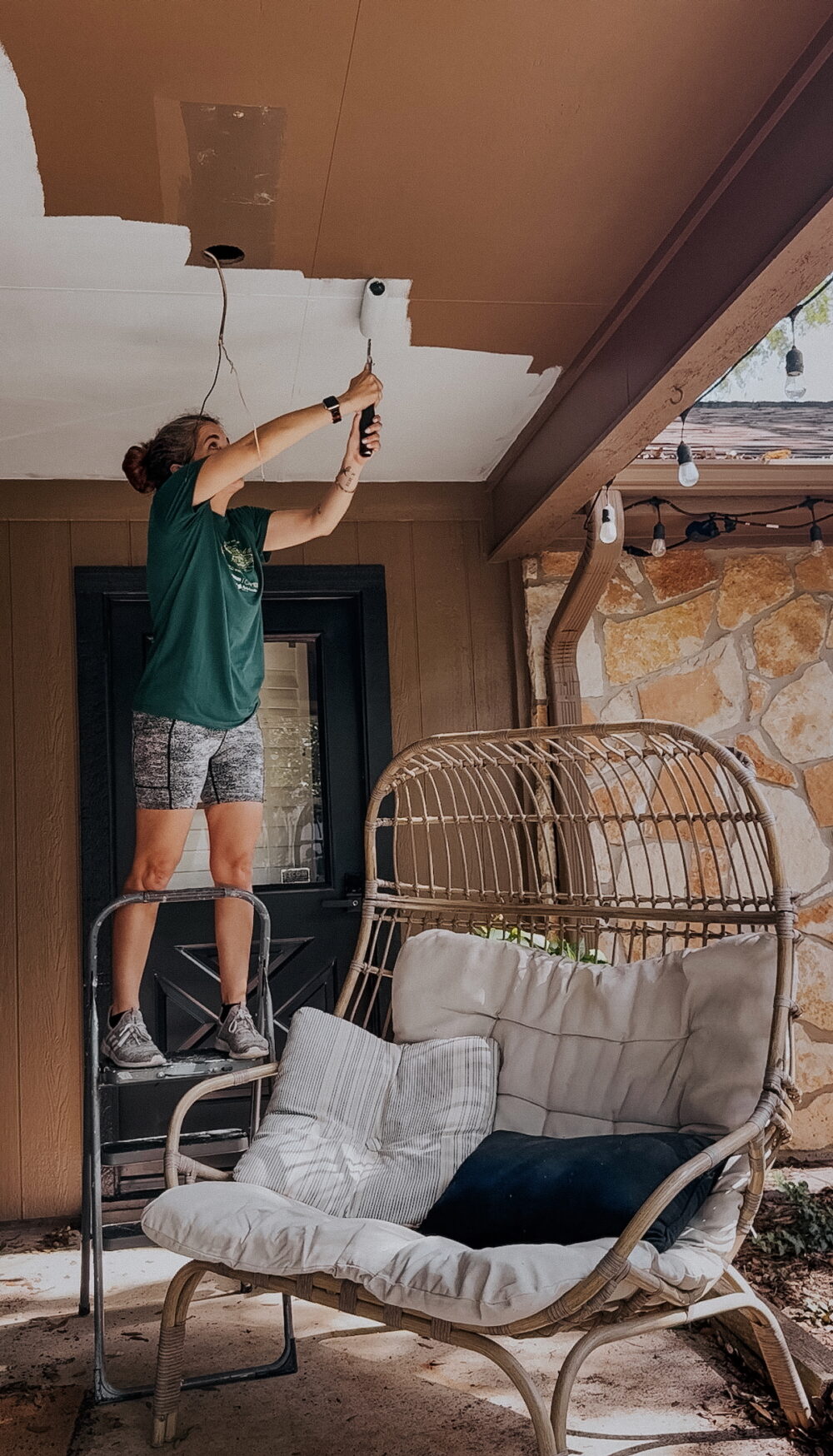 woman painting a patio ceiling
