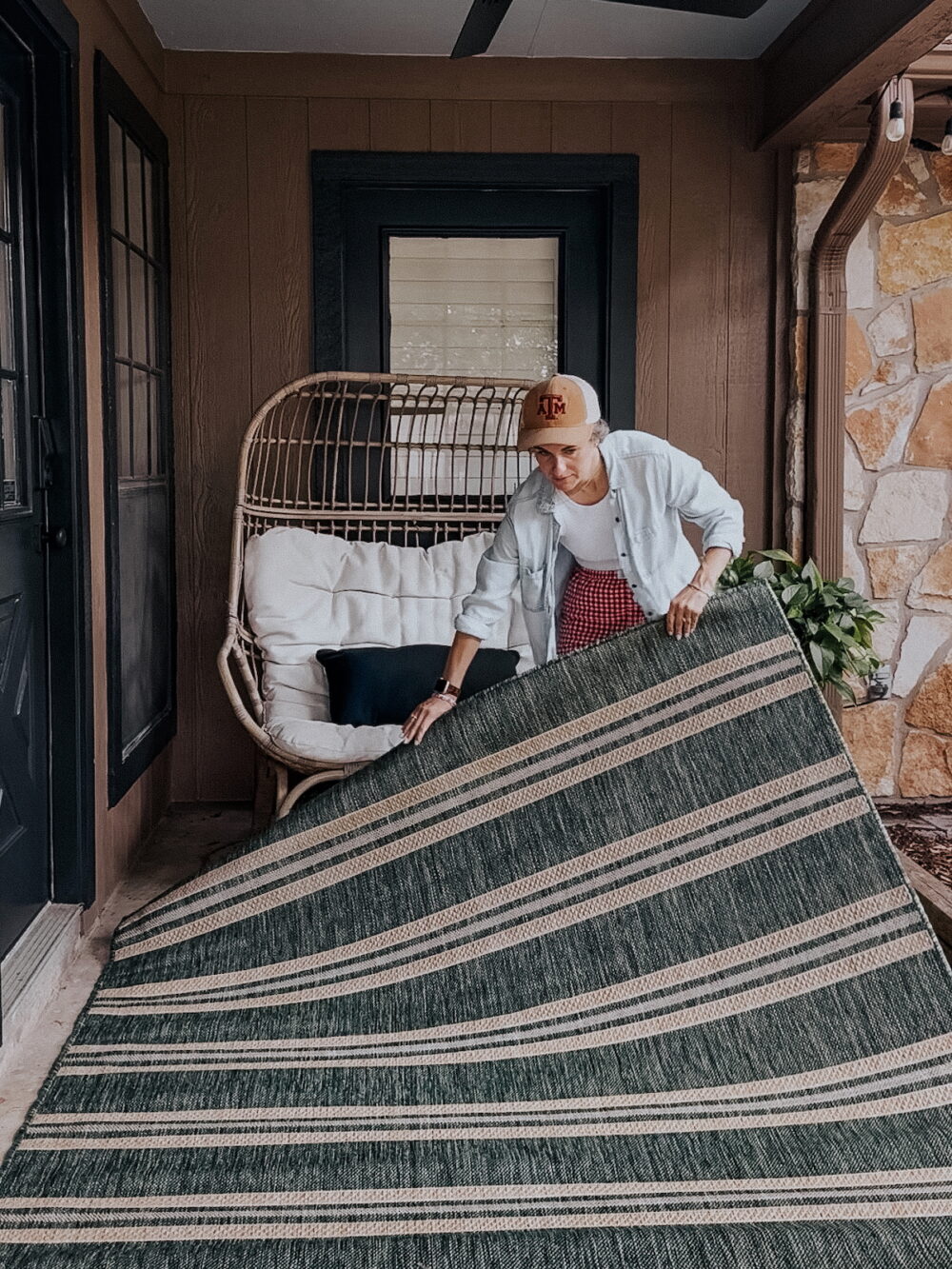 woman laying a rug on an outdoor patio