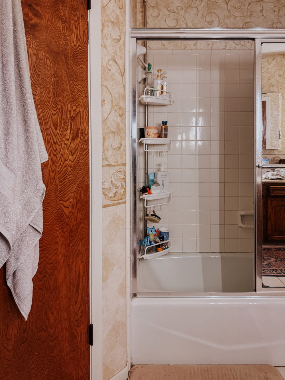 a bathtub shower combo in a dated bathroom
