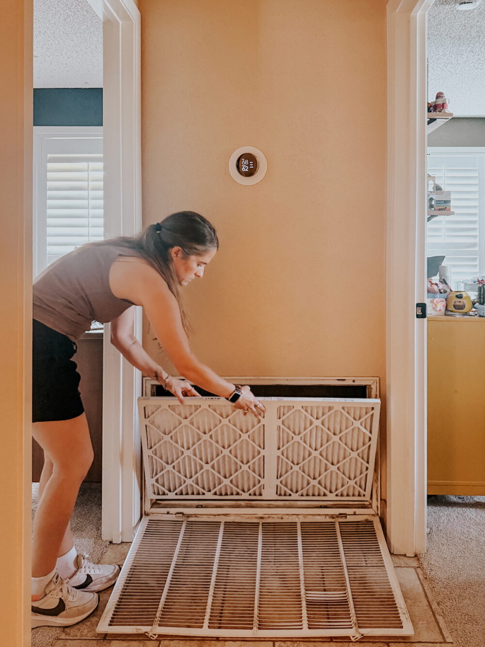 woman opening an air return to change the air filter