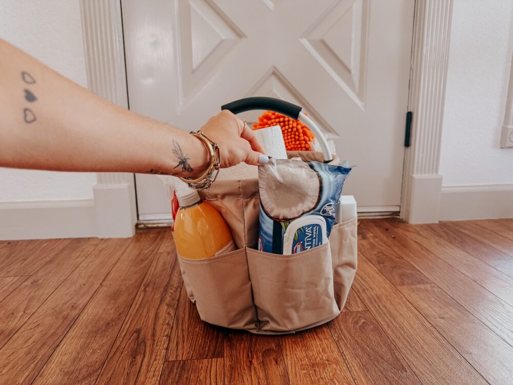 woman's hand grabbing clorox wipes from a cleaning caddy