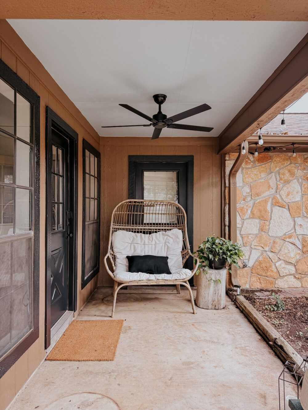 small patio with a blue ceiling and a black fan