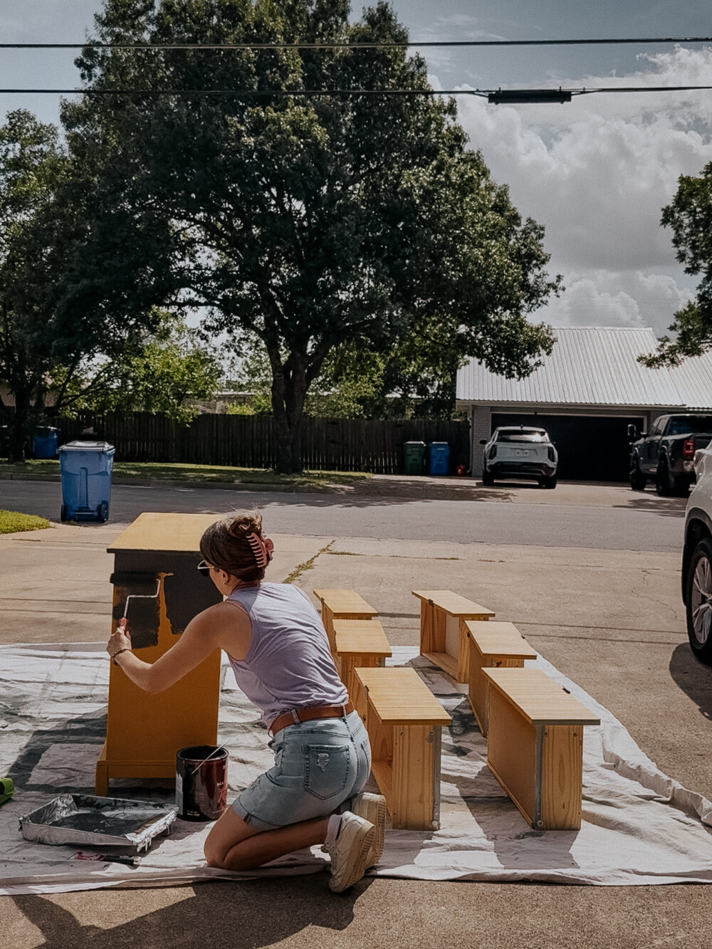 woman in a driveway painting an IKEA dresser
