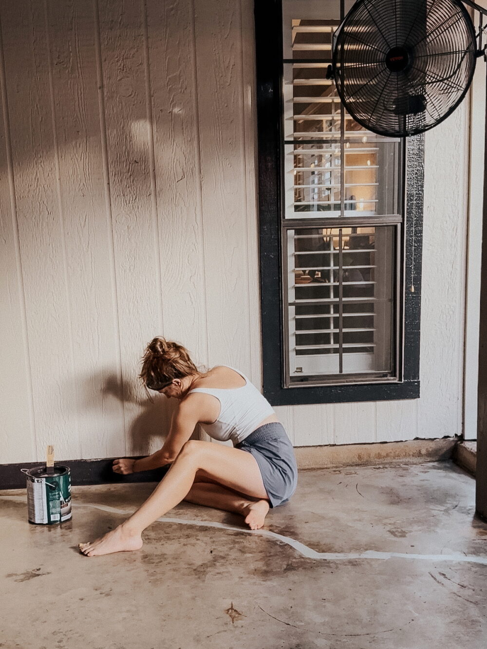 woman painting a concrete patio floor