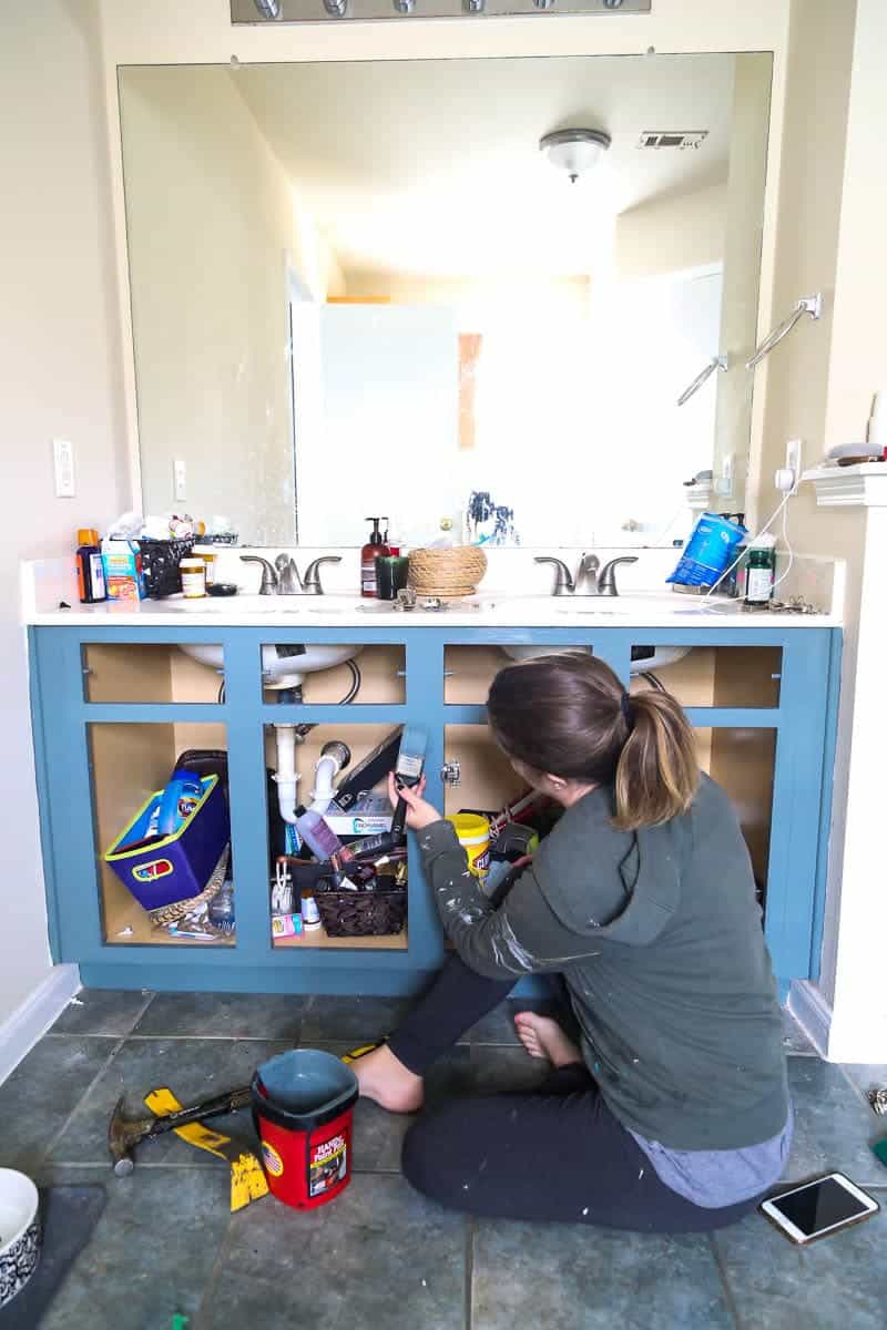 woman painting a bathroom vanity