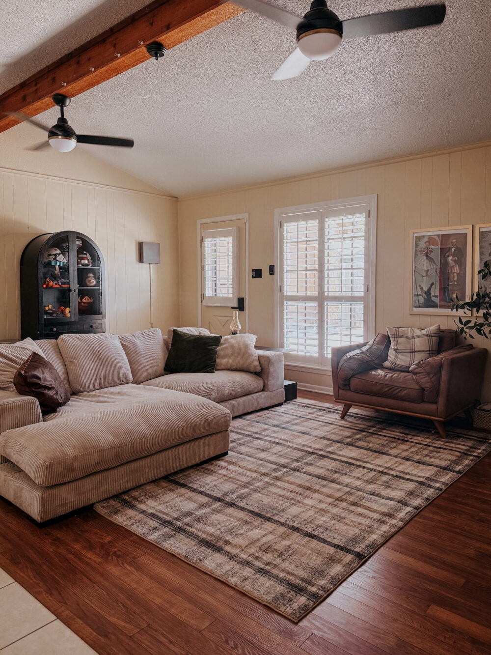 large room with an oversized sofa and a plaid rug