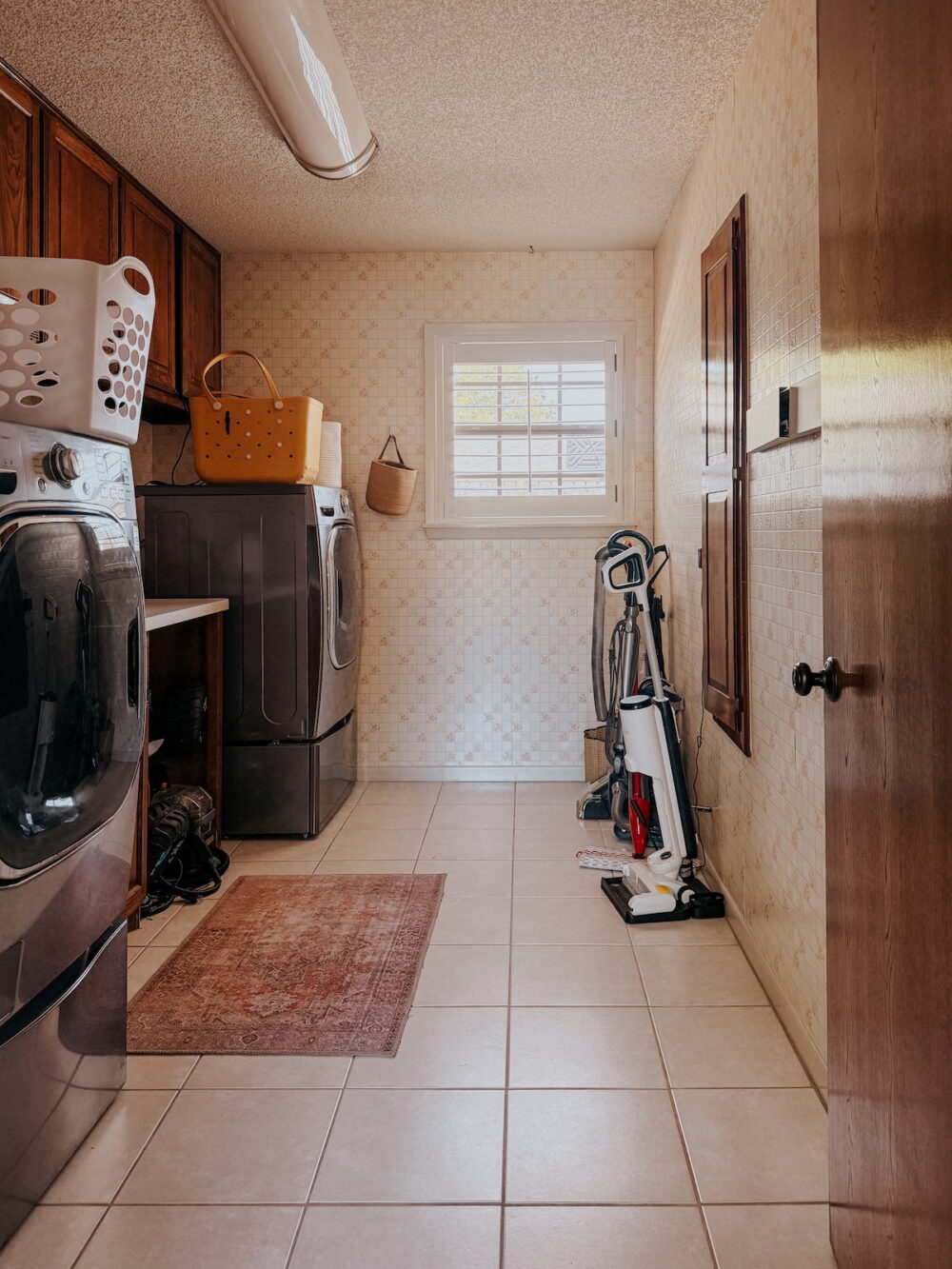 large laundry room with floral grid wallpaper and a window