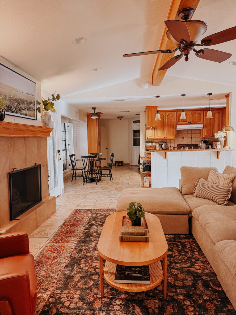 living room with vaulted ceilings nad a wood beam and a large overstuffed sofa