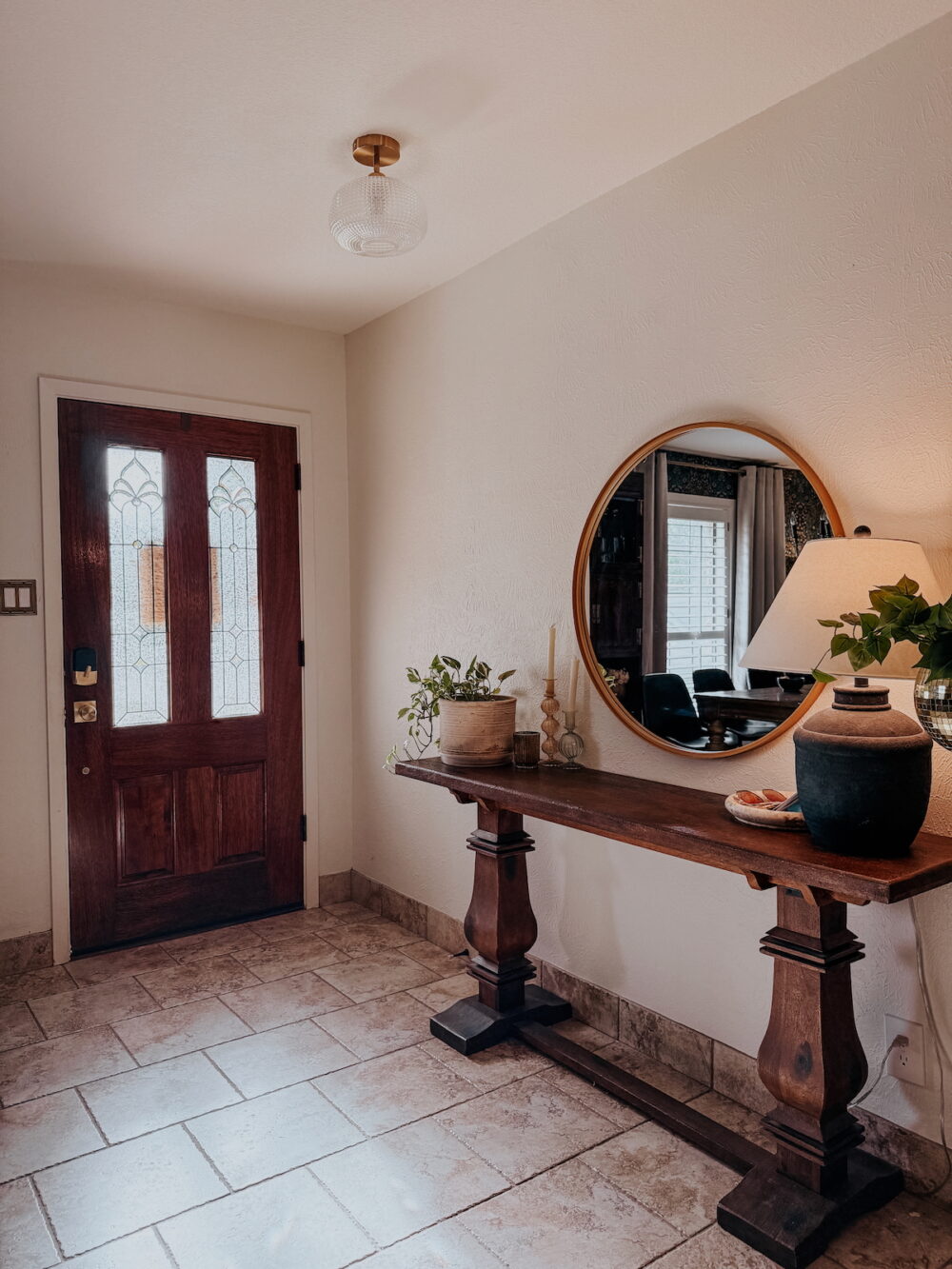small entryway in a 70's home with dated tile and an open entry table