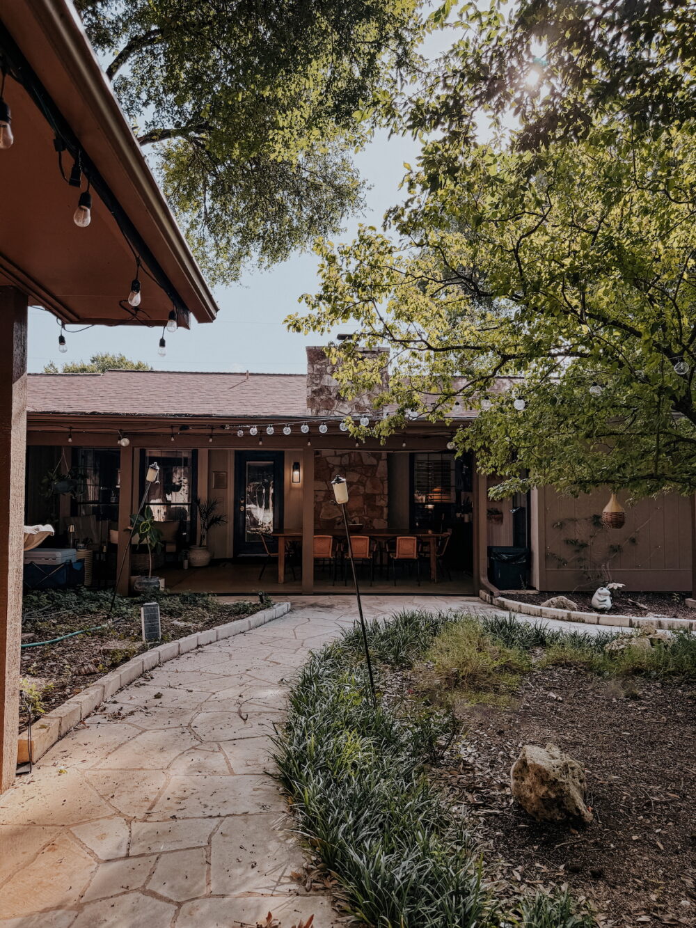 back view of house with patio and large trees