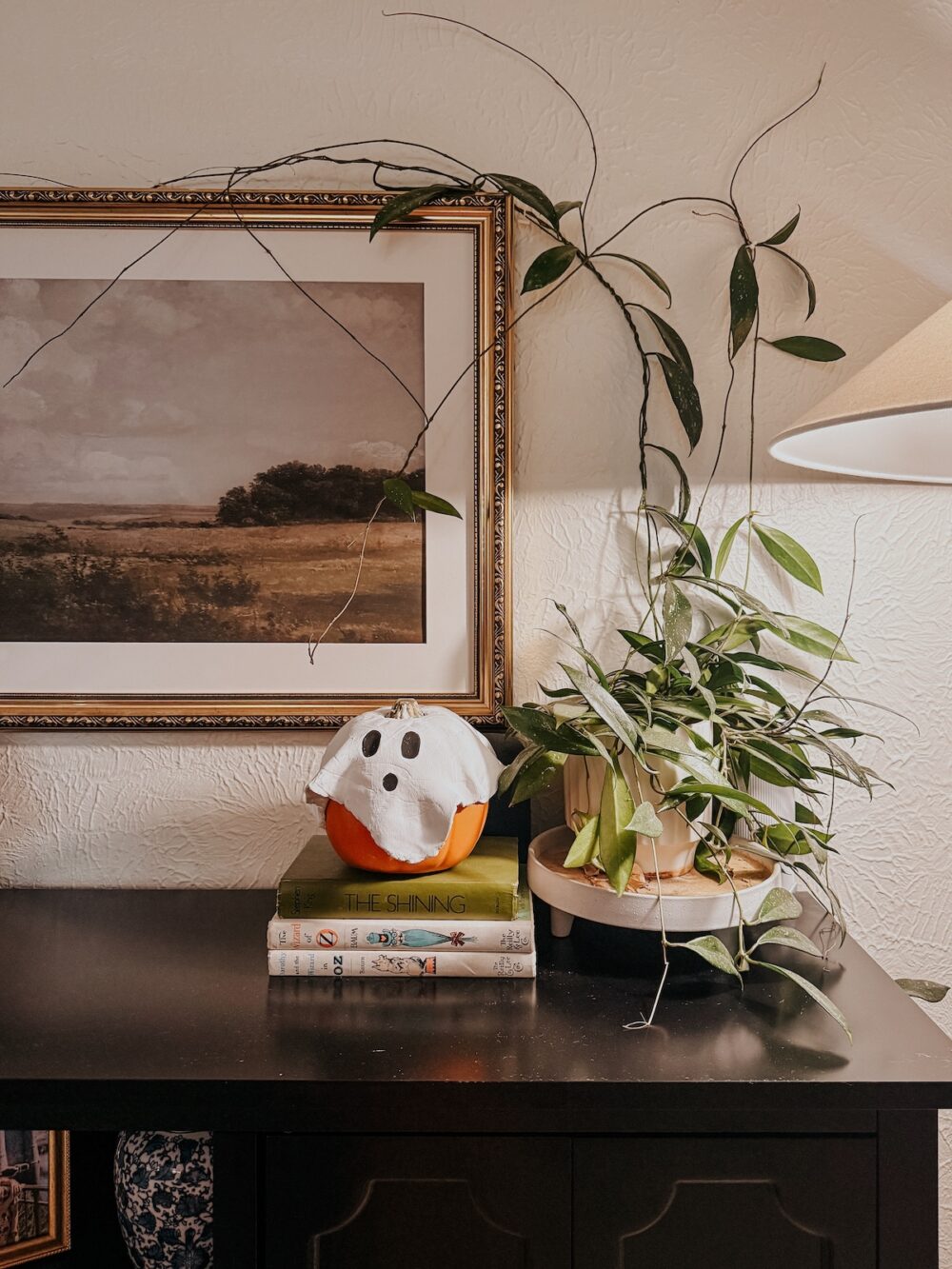 side table styled for halloween with a DIY air dry clay ghost pumpkin