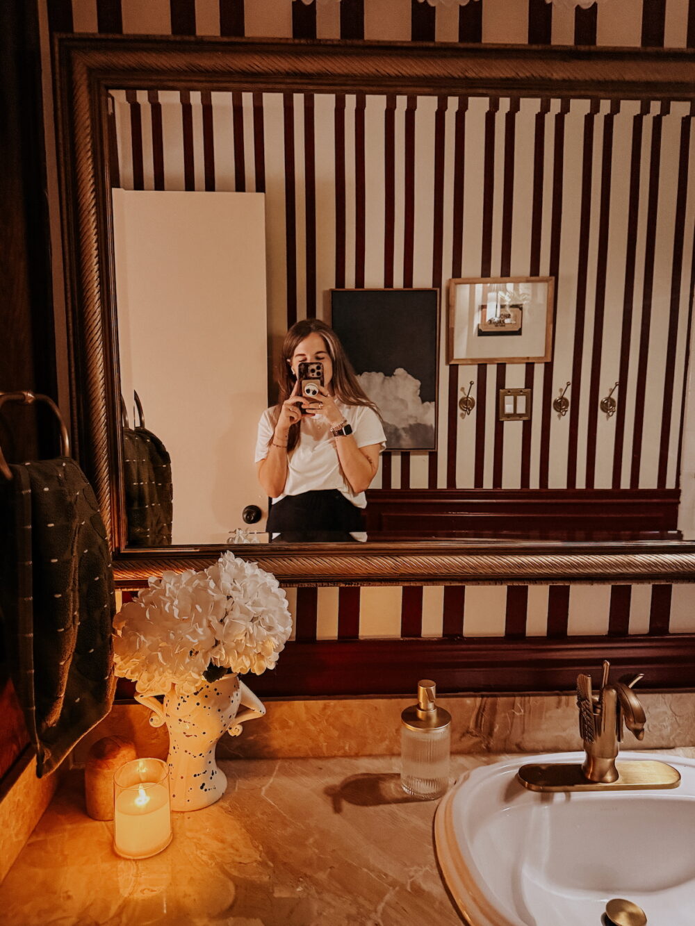 woman standing in front of a mirror in a cozy vintage-inspired bathroom