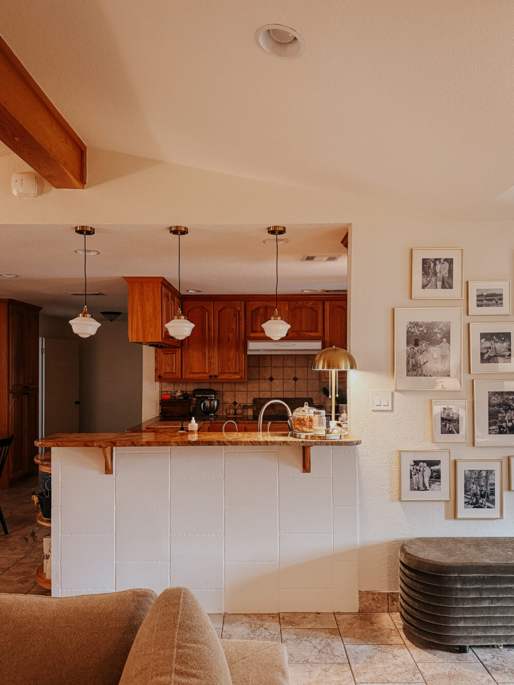 great room looking into a kitchen with schoolhouse pendants hanging above the bar