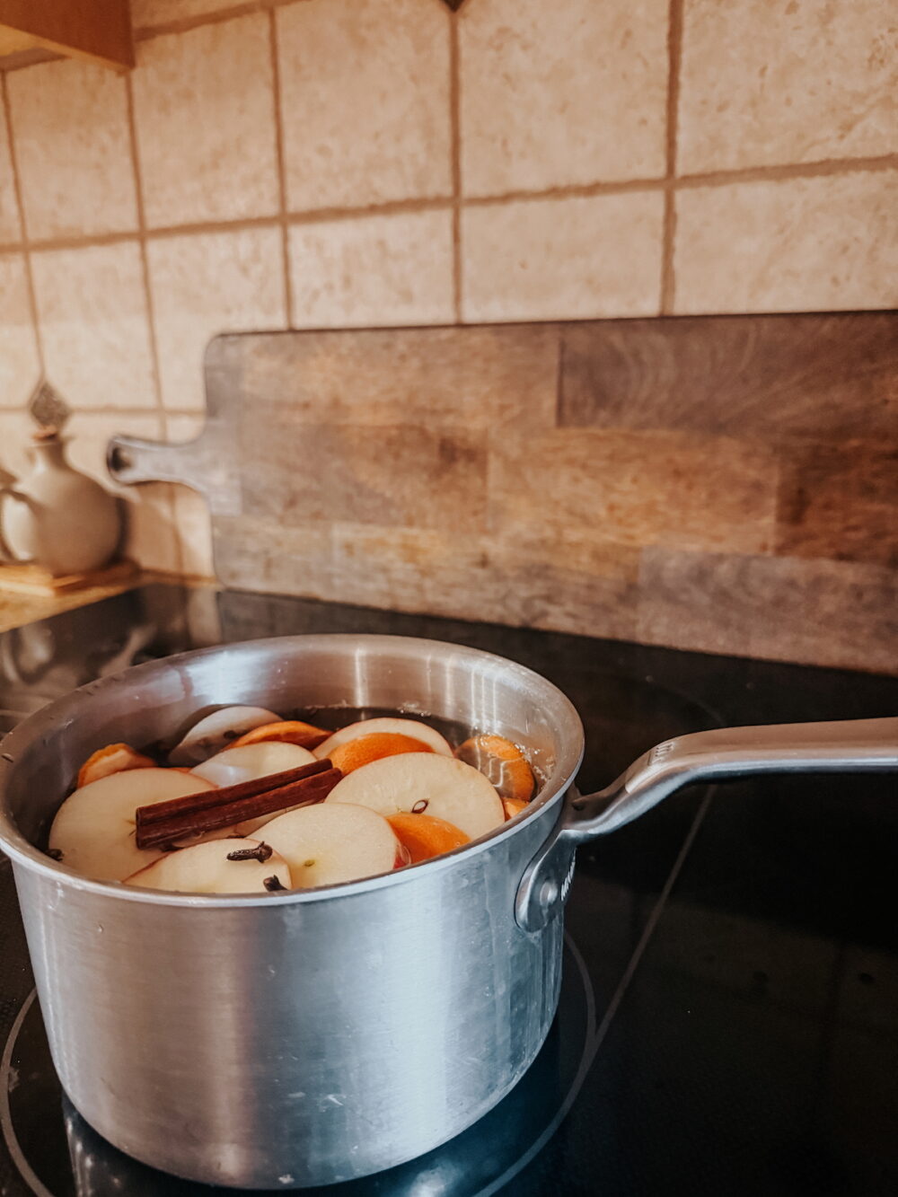 close up of a pot on a stovetop with ingredients to make a fall simmer pot