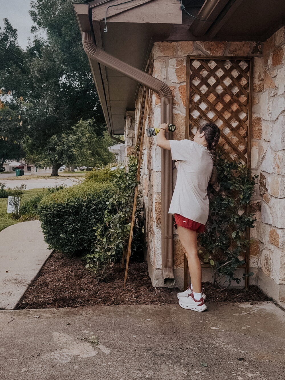 woman removing a downspout from a gutter