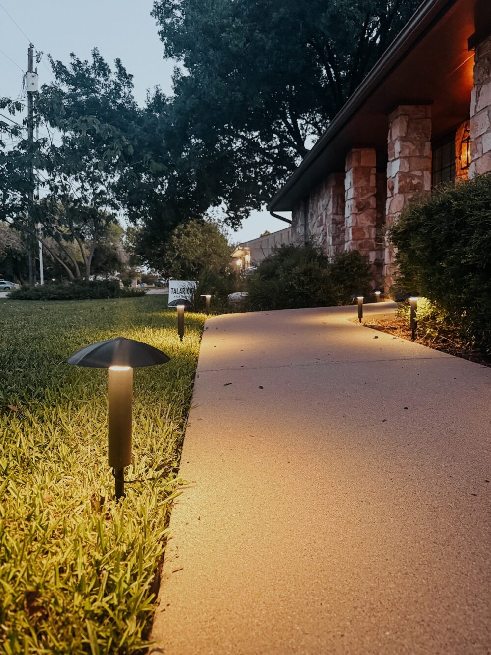 close up of a plug in pathway light next to a sidewalk