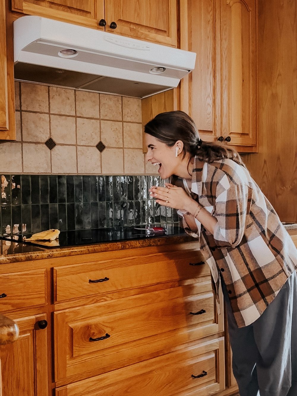 woman celebrating installing peel and stick backsplash tiles